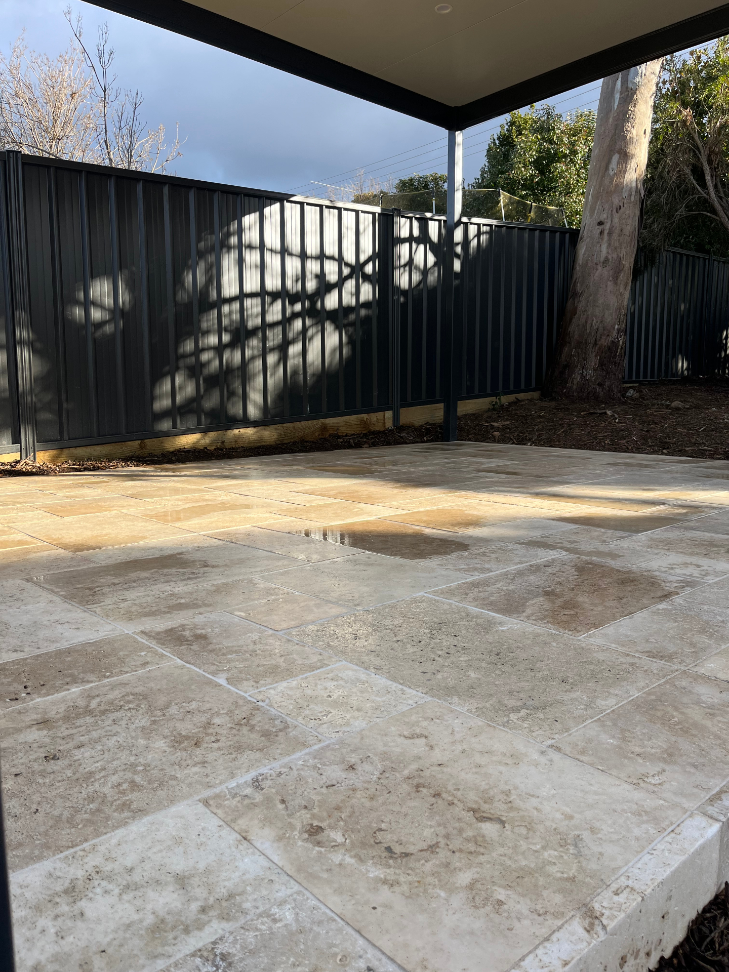 Modern paved entertaining area with retaining wall
